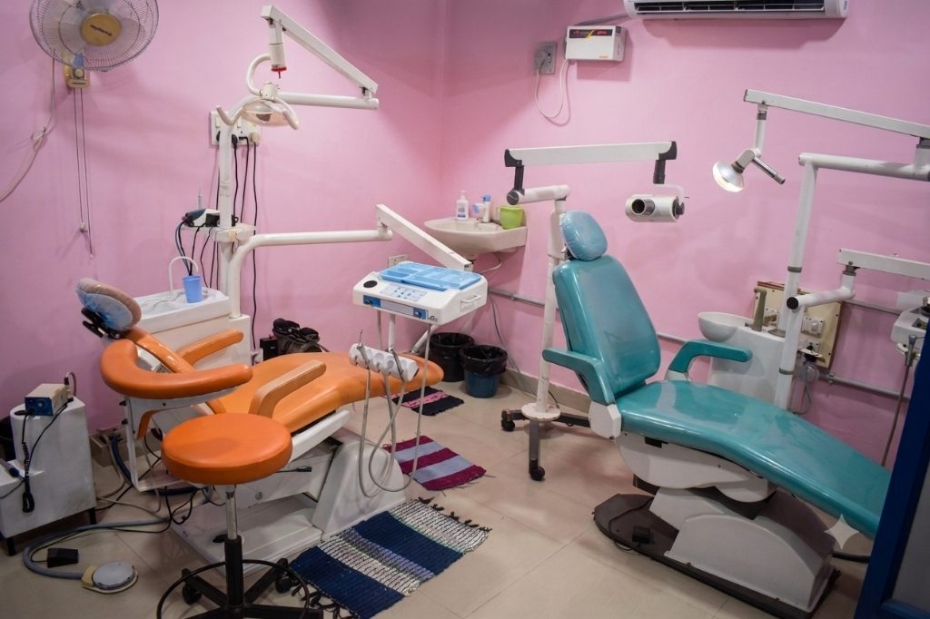 Main treatment room with orange and teal dental chairs at Magna Dental Clinic